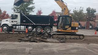 Excavator loading broken asphalt