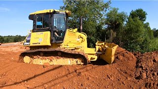 Building a new road across a deep ditch with a Cat excavator and a Komatsu bulldozer.