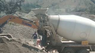 MIXING CONCRETE CEMENT USING EXCAVATOR AND TRANSIT MIXER.