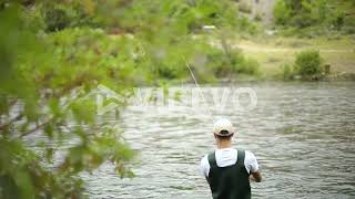 Slow Motion Shot of a Caucasian male fisherman casting his hook while Fly Fishing