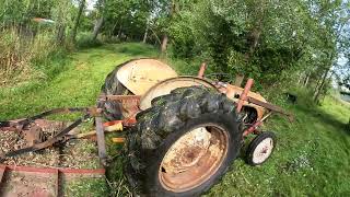 Antique 8N ford tractor mowing with brush hog