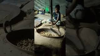 peanut frying || little boy doing hard work to fry peanuts .