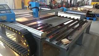 Mini gantry CNC cutting machine with plasma source for Iron works, metal sheet fabrication area.