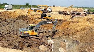 Road construction/ Two Excavator SANY SV215C and Excavator Volvo EC210Dl digging dirt mix mud