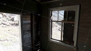 View through the windows inside a wooden abandoned house. Clip. Old ruined wooden building and a