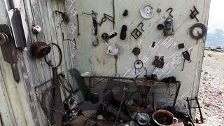 Wall of an old garage building with hanging interesting vintage items. Clip. Different old rusty