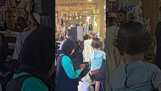 Woman in egypt holding a TV on her head