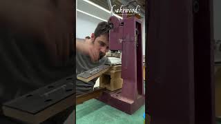 Technician is pressing the frets into the fingerboard of an acoustic guitar!