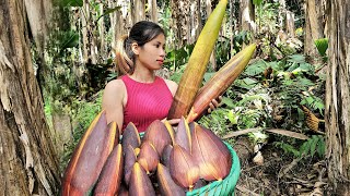 The girl goes into the forest to collect banana flowers to sell.