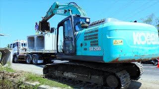 Kobelco Excavator Truck Unloading And Installing Precast Box On The Storm Drain Construction