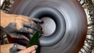 Throwing a donut shape in black stoneware. Real time, full length.