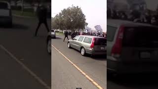 BLM protestor steps onto the street. turns back to a moving car.