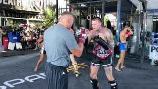 Eddie Farrell coaches pad work with One Championship fighter Anotoly Malykhin