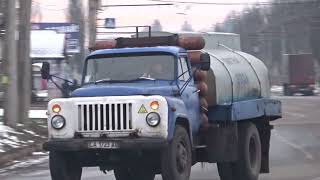 An old GAZ-53 with gas cylinders and a tank carries drinking water