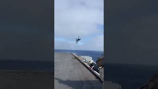 What a fast  fighter! Flying over an aircraft carrier.