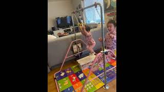 Kids wearing matching Hello kitty pajamas doing gymnastics & swings at in home gymnastic swing set