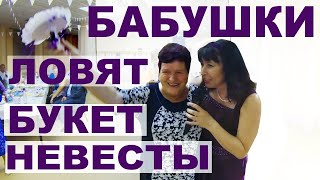 Бабушки ловят букет невесты на свадьбе.