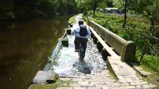 Cycling over a weir on the Rochdale Canal