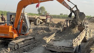 Powerful Excavator Loading Soil onto a Trolley