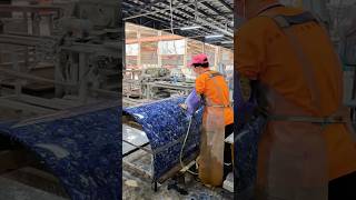 Polishing a curved blue luxury stone slab with a semi-automatic hand grinder