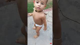 A Cute Baby Playing With Flowers .