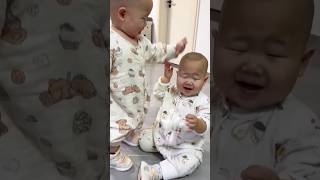 Baby twins stand together and laugh