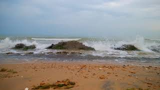 The Sound Of Calm Sea Waves Crashing On Rocks And Cloudy Sky