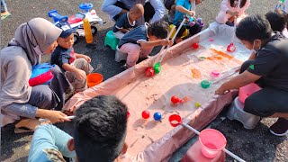 mbak nuara dan Khabir serok anak ikan lele dan nila di dalam kolam terpal kecil.