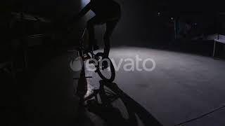 BMX rider doing tricks in dark warehouse. | Stock Footage - Envato elements