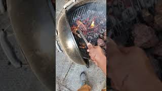 cooking up a storm on the weber 22" charcoal bbq steaks frying