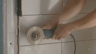 Construction workers using grinder to trim tiles edges at the construction site. Worker hands