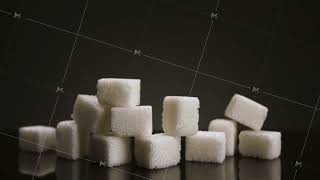 A pile of sugar pieces against black background. Stock footage. Close up of sweet sugar as a symbol