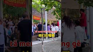 a group of senior citizens gather in the central park of the city to sing songs. #mandarin