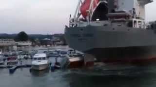 Navio destruindo barcos em marina