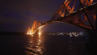 HMS Queen Elizabeth passes under bridges in the dead of night