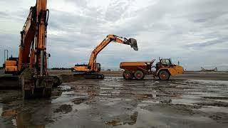 From a distance I saw an excavator loading sand into the truck