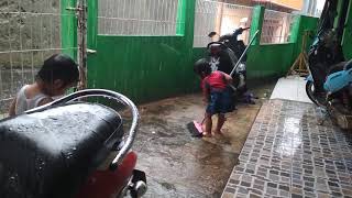 Anak kecil mandi hujan