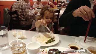 Niña pequeña comiendo jengibre crudo y judías verdes con chile