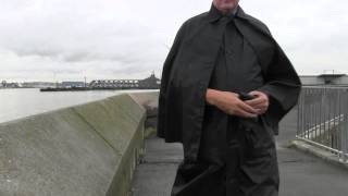 Wearing a Black nylon cape by the river