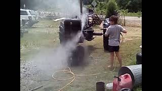 Chris power washing his  C Farmall Tractor