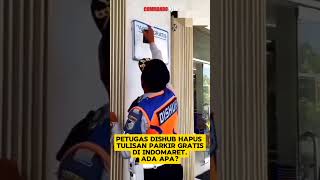 Seorang oknum petugas Dishub menghapus tulisan parkir gratis di depan Indomaret