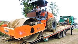 Loading Delivery Unloading Soil Compactor From The Road Construction Site Using Self Loader Trucks