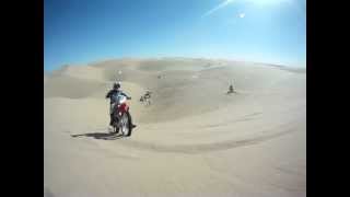 Wheelie up dune on dirt bike