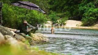 Man from Rag Lai tribe fishing with rod in countryside river in Vietnam