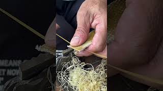 A craftsman demonstrates his technique of pulling bamboo into thin filaments