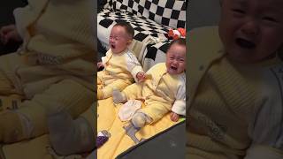 The three twin babies stood by the window, facing each other at the same time.