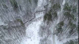 Drone circling above the winter forest river below