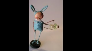 scary little boy creature with rabbit ears holding very cute adorable doll creature figurine