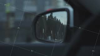 View from inside the driving car on a side mirror. Stock footage. Details of car interior and side