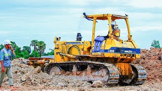 Perfect action for fast Komatsu D58E bulldozer pushing soil and 5Ton trucks dumping soil fill upland